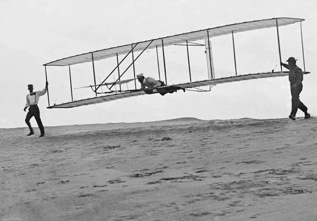 Historic photo of the Wright brothers' third test glider being launched at Kill Devil Hills, North Carolina, on October 10, 1902.
